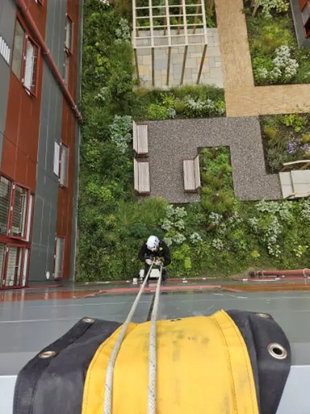Rope access technician cleaning high-rise windows