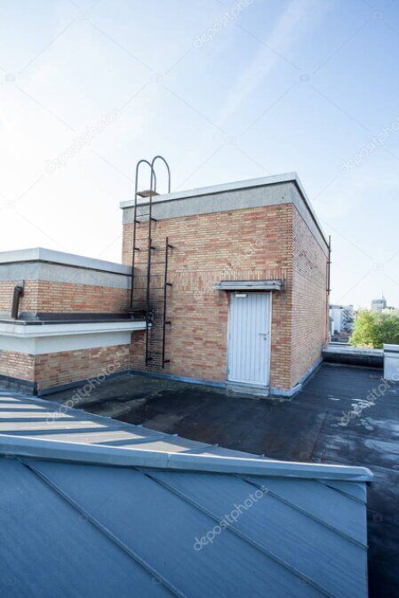 Rope access worker cleaning gutters along a roofline