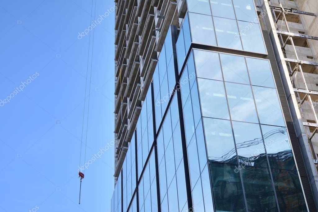Technician cleaning a building facade using rope access