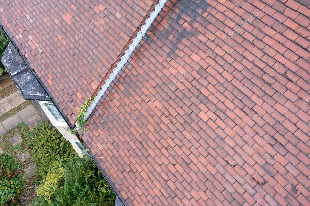 Technician cleaning gutters and roofline using rope access