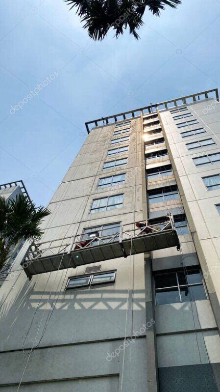 Rope access worker cleaning a building facade at height