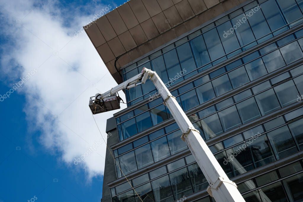 Technicians installing signage on a tall building using rope access